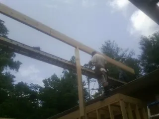 Carpenter setting a ridge beam over a new addition frame — Ice Dam Removal by Roofing Brothers in Elwood