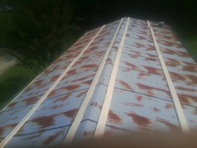 Rusted metal roof panels with new wood purlins before replacement — Storm Damage Roof Repair in Elwood by Roofing Brothers